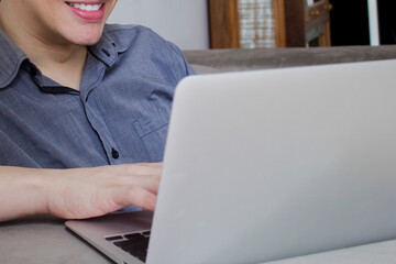 Young casual entrepreneur working on laptop at home office.
