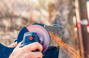 Angle grinder in action grinding metal with sparks in outdoor industrial setting