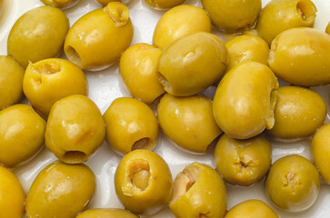 Scattered green olives on white surface for a mediterranean appetizer