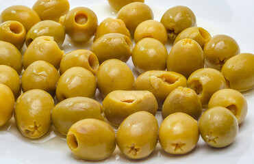 Pitted green olives arranged on white surface for a healthy snack
