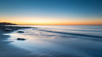 Obraz premium Golden Hour on Serene Shore: Rocks Sea and Sky 