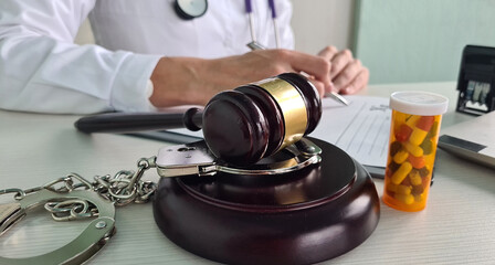 Judicial gavel pills handcuffed doctor with medical prescription