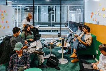 Multiracial male and female students spending leisure time in modern classroom at university