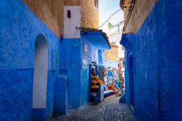 Photo sur Plexiglas A cozy blue street with a small grocery store in the center of the Medina of Chefchaouen, the blue city