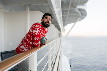 Man drinking coffee on a cruise ship by the ocean