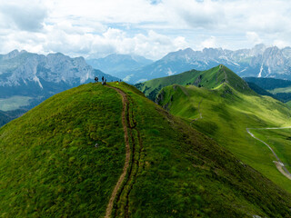 Naklejka premium Aerial Drone View of the Dolomites in Summer, Showcasing Majestic Peaks, Green Valleys, and a Stunning Alpine Landscape Under a Clear Blue Sky with Clouds