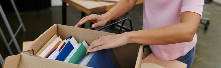 Organizing books and files while moving into a new modern workspace in the afternoon light