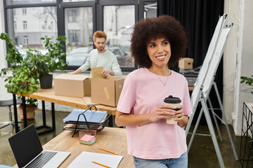 Brightly lit modern workspace featuring individuals packing and sipping coffee during a moving day