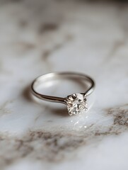 A diamond solitaire engagement ring is displayed on a light marble-like surface