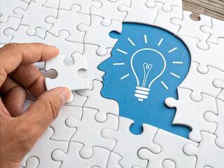 Hand placing puzzle piece, representing a solution to a problem.