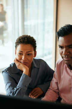 Aff&auml;rskvinna sitter med manlig kollega och arbetar p&aring; dator