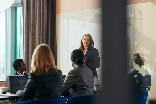 Aff&auml;rskvinna presenterar inf&ouml;r kollegor under m&ouml;te