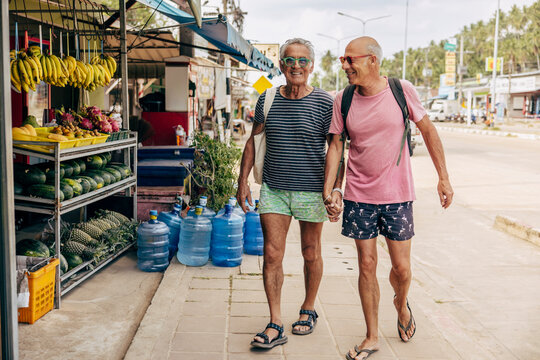 Leende &auml;ldre man h&aring;ller hand med partner