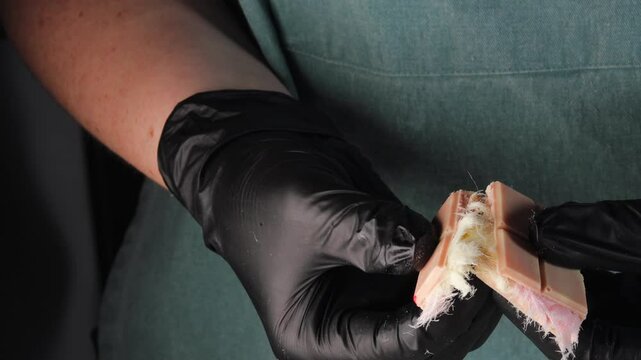 Hands in black gloves breaking Chocolate bar with cotton candy angel hair (pismaniye). close-up for confectionery and culinary theme