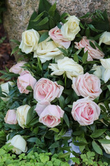 Memorial flowers at the grave. Beautiful funeral flowers at the cemetery. Roses and other flowers tied into a funeral bouquet. Flowers comfort loved ones grieving the deceased. 