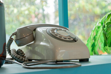 Retro green telephone with garden background. After edits.
