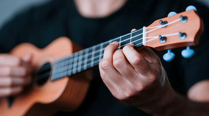 Fototapeta premium Close Up of Hands Playing a Brown Ukulele