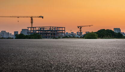 Obraz premium Urban Construction Landscape at Sunset with Cranes and Framework