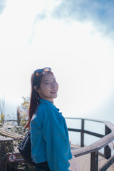 A woman in a blue jacket is smiling and posing for a picture