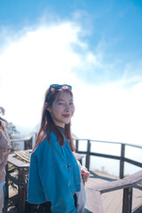 A woman in a blue jacket is smiling and posing for a picture