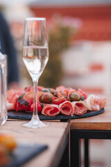 A beautiful glass of wine is elegantly placed on a table right next to a delicious plate of food, enhancing the dining experience