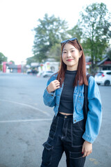 A woman wearing a blue jacket and black pants is standing on a street
