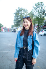 A woman wearing a blue jacket and black pants is smiling