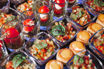 A beautifully arranged table is topped with a delightful assortment of appetizers that includes colorful tomatoes and fresh vegetables, perfect for any gathering