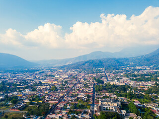 Obraz premium Panoramic view of the city of Antigua Guatemala, under a beautiful blue sky with clouds on the horizon.