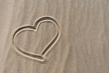 hand drawn heart on dry sand in desert