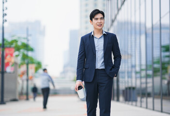image of a young asian businessman drink coffee on the street