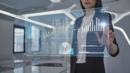 Strategic Analysis: A businesswoman interacts with a holographic interface displaying dynamic data visualizations, showcasing the future of business.