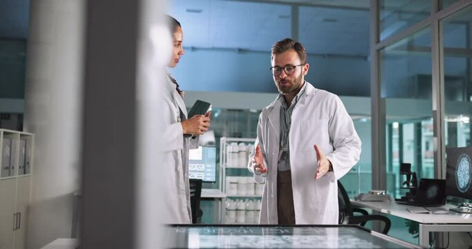 Scientist, research or discussion with tablet in lab for pharmaceutical review, medical comparison or innovation. Night, people or interactive display for studying science data, teamwork and results