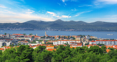 A stunning panoramic view of Zadar, Croatia, showcasing its iconic red rooftops, modern and...