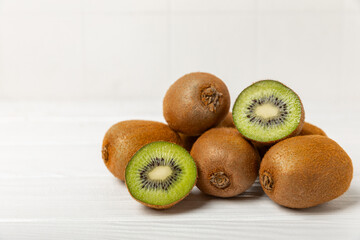 Kiwi on wooden background. Whole fruit and slices pieces of green kiwi on table. fresh ripe juicy...