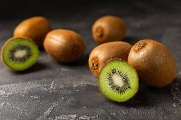 Kiwi on wooden background. Whole fruit and slices pieces of green kiwi on table. fresh ripe juicy...