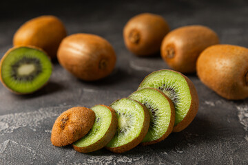 Kiwi on wooden background. Whole fruit and slices pieces of green kiwi on table. fresh ripe juicy...