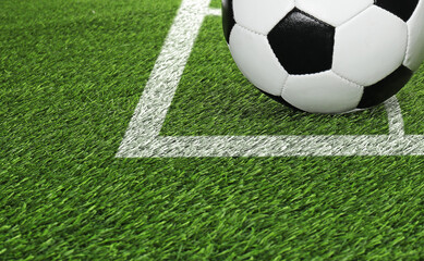 Football field with markings and soccer ball on green turf