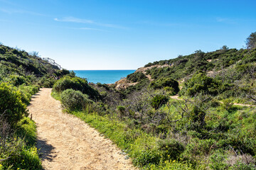 Praia da Marinha Beach among rock islets and cliffs seen from Seven Hanging Valleys Trail, Algarve,...