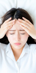 Naklejka premium Woman in distress, holding forehead, experiencing headache, stress, and tension, lying in bed