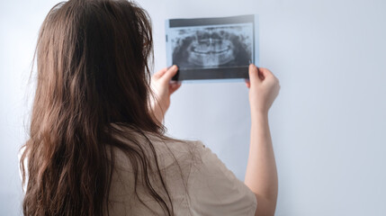 Experienced dentist assesses patient's dental condition through X-ray image for accurate diagnosis.