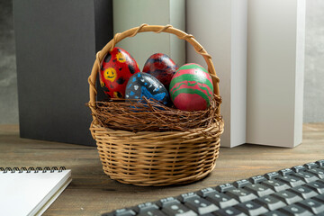 Wooden basket and a nest filled with colorful decorated easter eggs on the table. Concept of celebrating the easter holiday