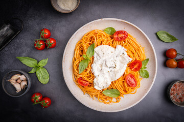 Pasta spaghetti with burrata and tomatoes and fresh basil, top down view. High quality photo