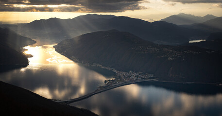 Golden Sunset Light Reflecting Over the Serene Waters of Lake Lugano Surrounded by Majestic Mountains