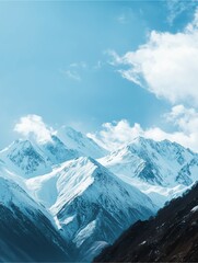 Obraz premium Majestic Peaks: A breathtaking vista of towering snow-capped mountains piercing the clear blue sky, with wisps of clouds dancing overhead.