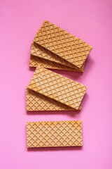 Waffles on a smooth pink background. perfect for illustrating a minimalist breakfast or dessert idea.