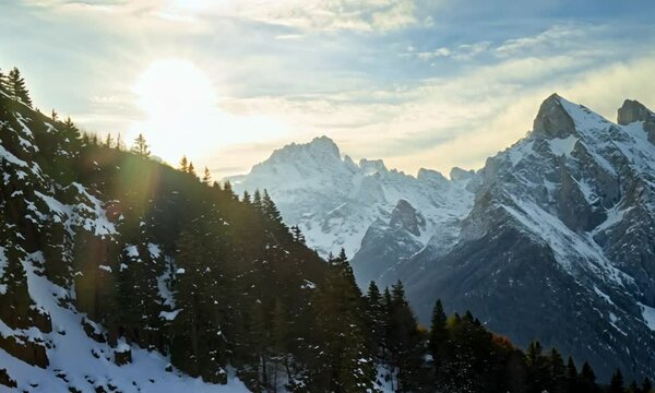 Snow covered peaks of the mountains in early spring. HDR. High magnificent alpine mountains under the shining sun, beauty of nature.
