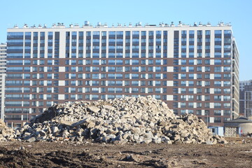 A pile of concrete fragments of an old building lies near a new apartment building, Oktyabrskaya Embankment, Saint Petersburg, Russia, March 27, 2025