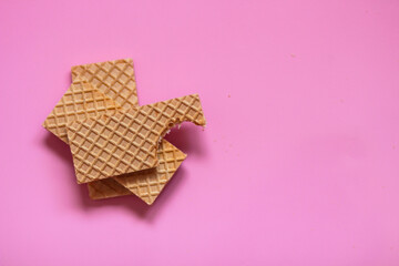 Waffles on a smooth pink background. perfect for illustrating a minimalist breakfast or dessert idea.