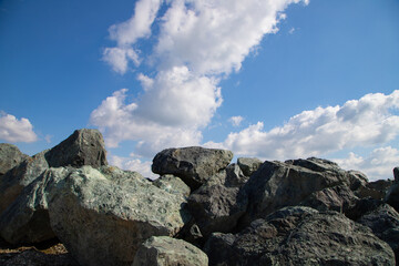 Excavation materials including sand and gravel stored at an industrial quarry for processing.